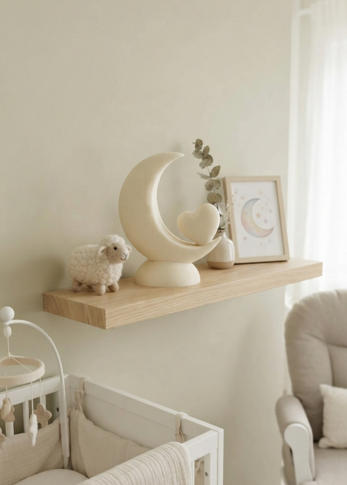 Orbit Luna biologisch afbreekbare mini-urn in maan- en hartvorm op een houten wandplank in een babykamer interieur